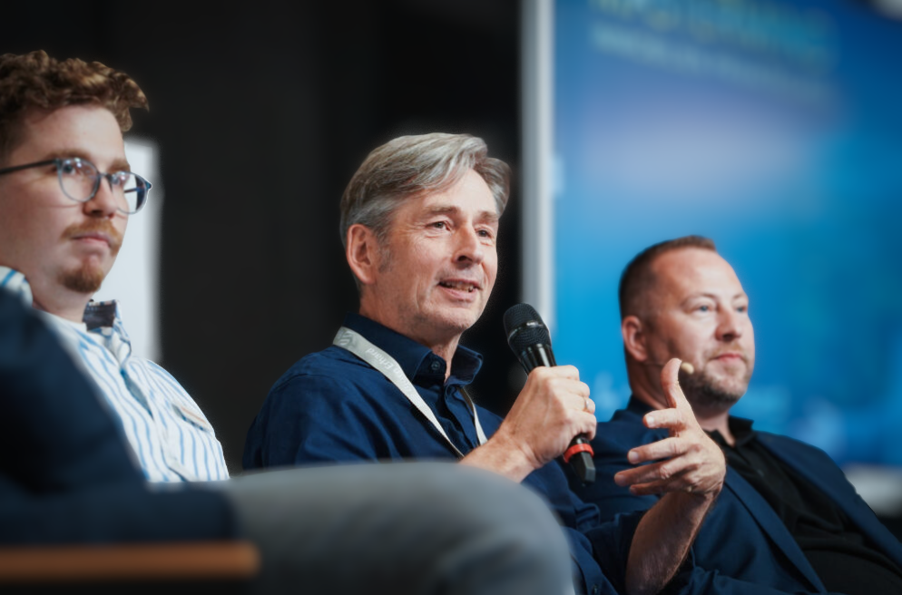 Ulrich Zimmermann mit Mikrofon in einer Panel-Diskussion